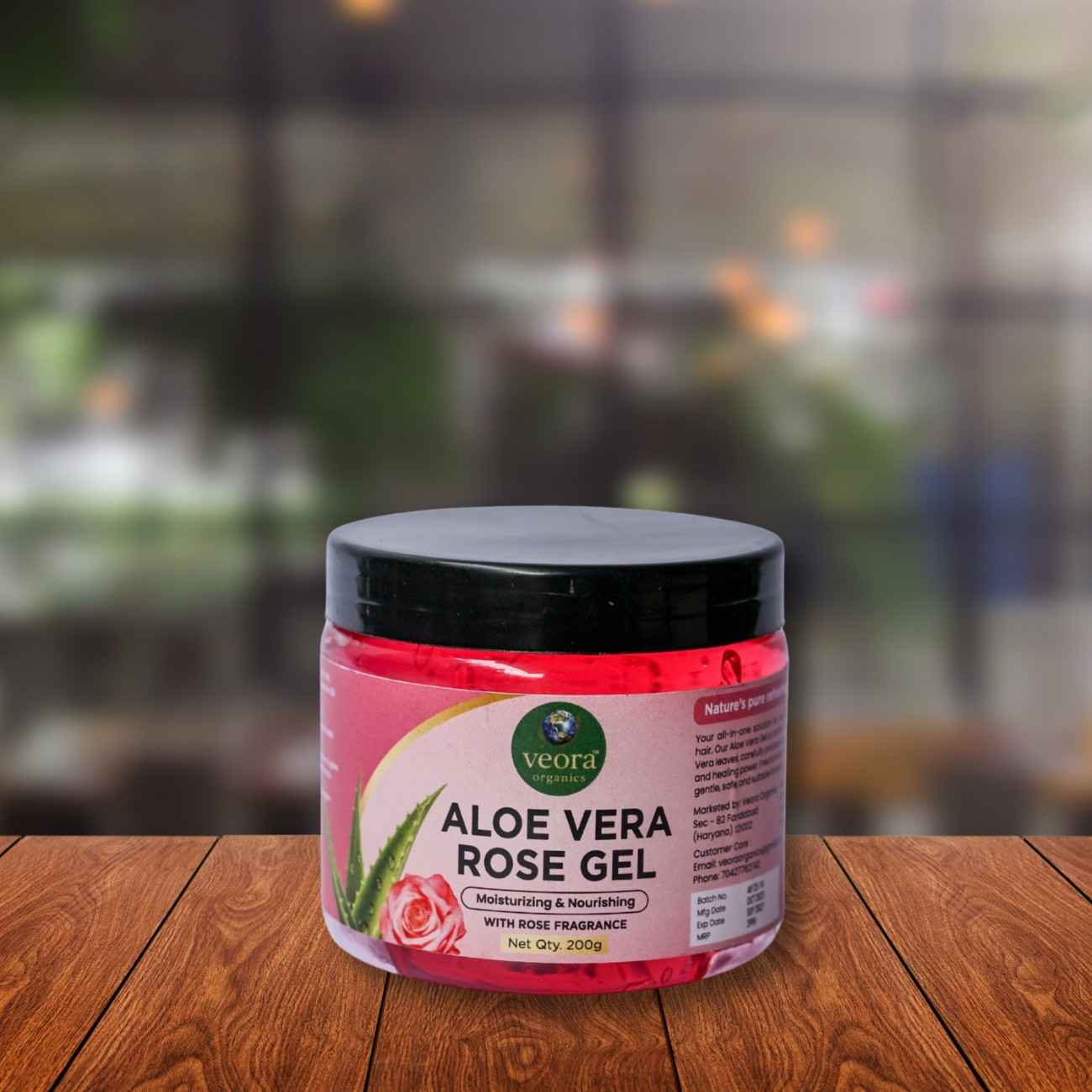 Jar of aloe vera rose gel on a wooden surface with a blurred background