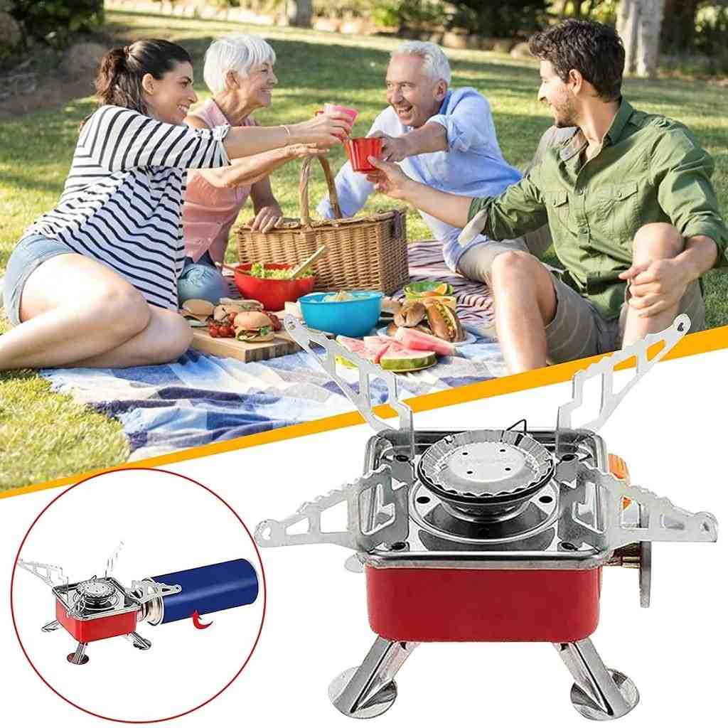People enjoying a picnic with a portable camping stove in the foreground.