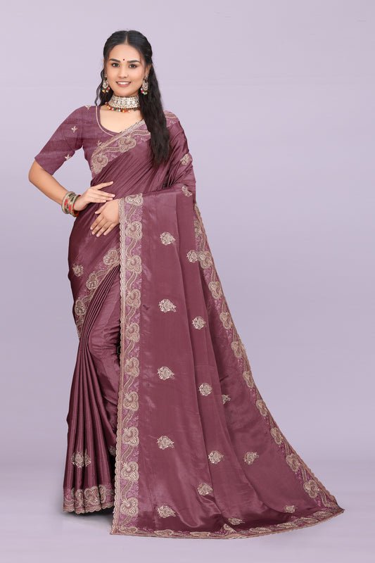 Woman wearing a mauve saree with gold patterns on a light purple background