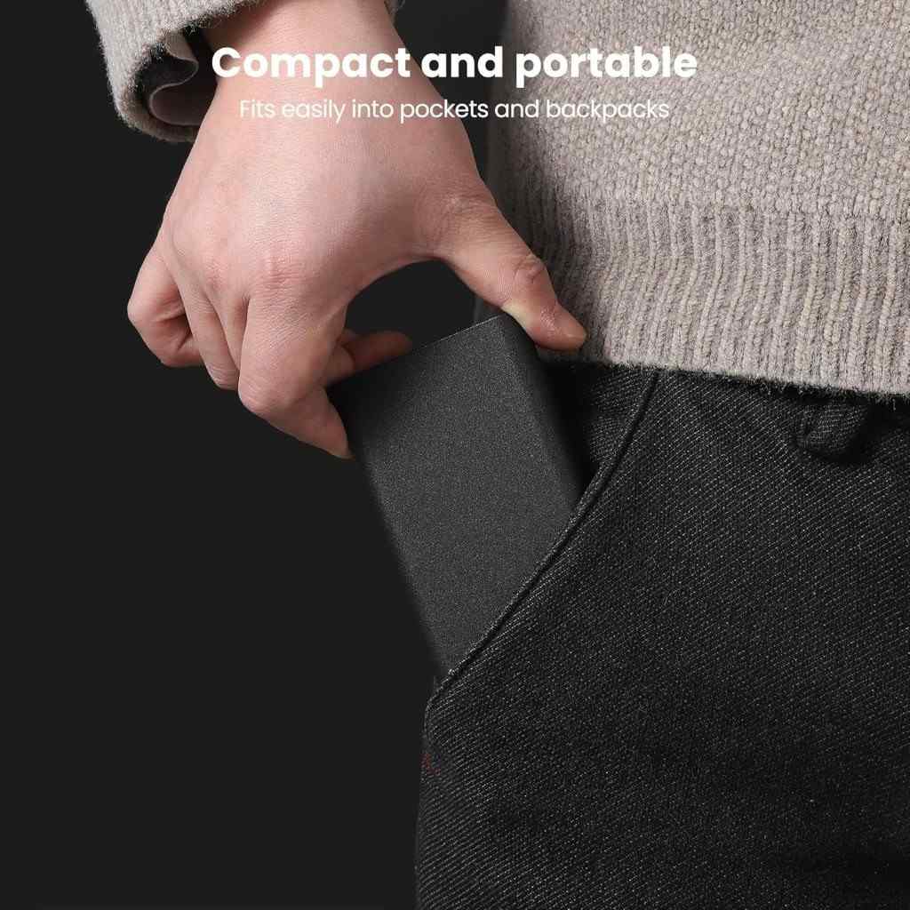 Person inserting a compact black device into their pocket with text 'Compact and portable, fits easily into pockets and backpacks'.