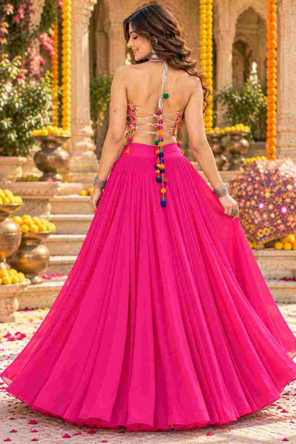 Backless view of pink georgette lehenga with colourful tassel string closure.