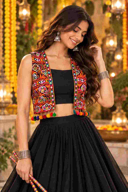 Close-up of a black crop top with a colorful pom-pom mirror jacket.