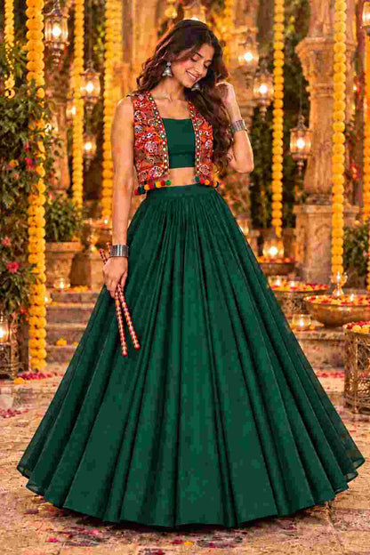Front view of a dark green lehenga choli set with a mirror-work jacket.