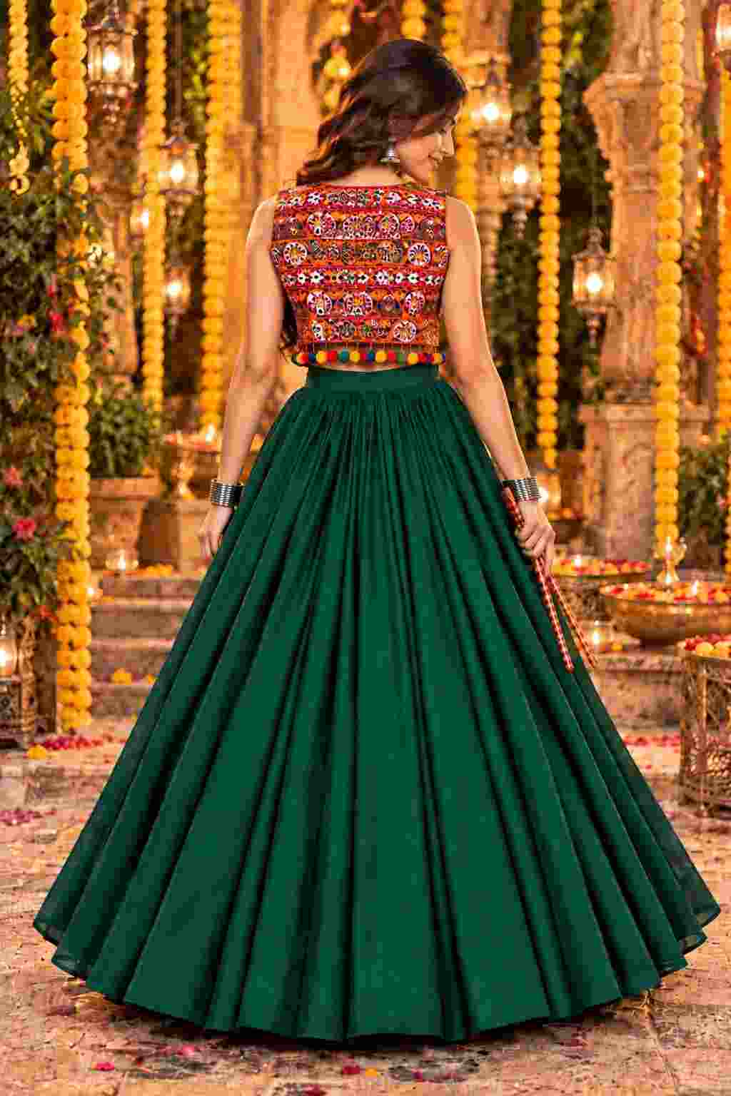 Back view of a green lehenga set with a pom-pom trimmed jacket.