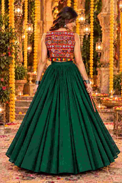 Back view of a green lehenga set with a pom-pom trimmed jacket.