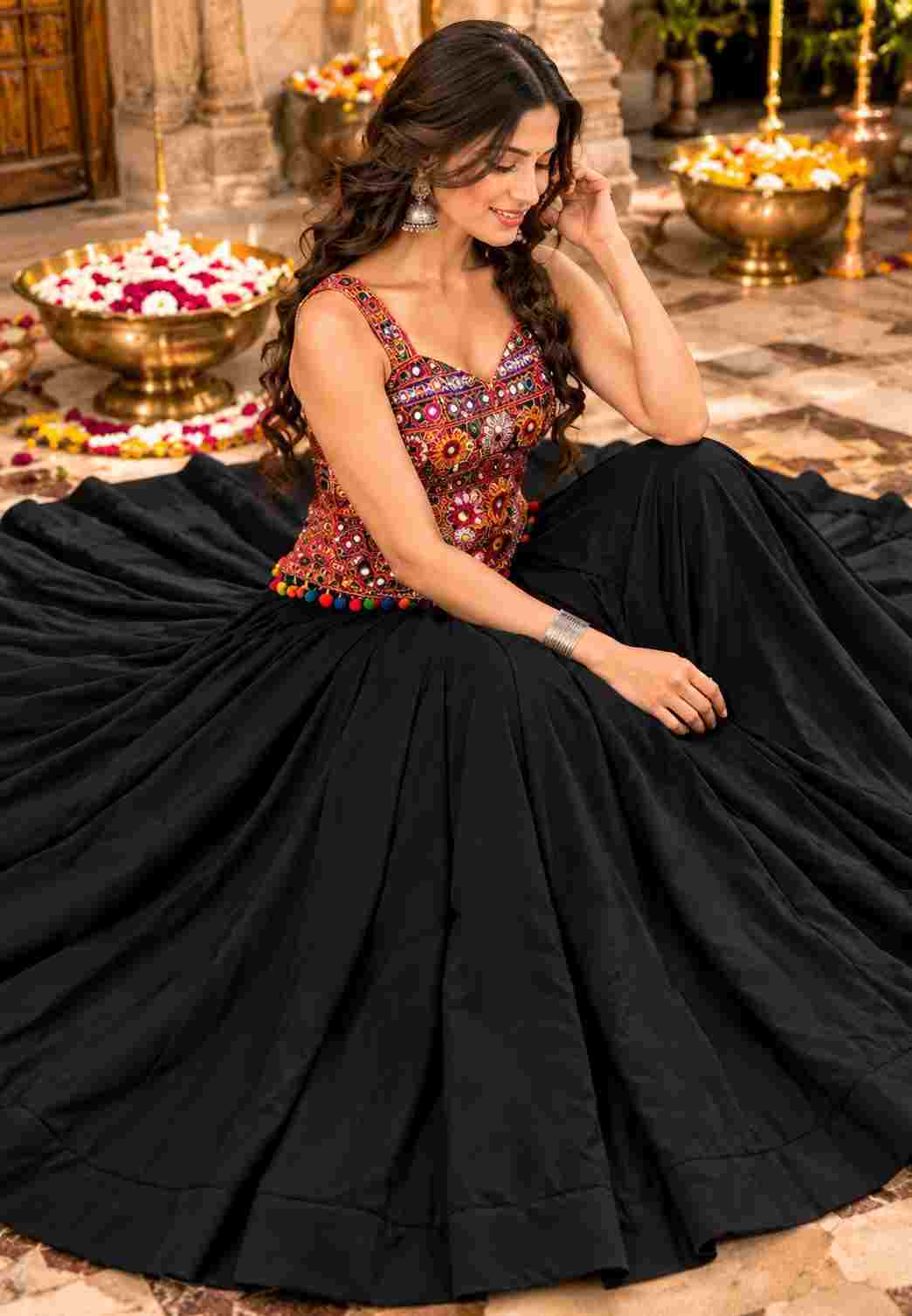 A flared black lehenga and embroidered mirror-work choli.   