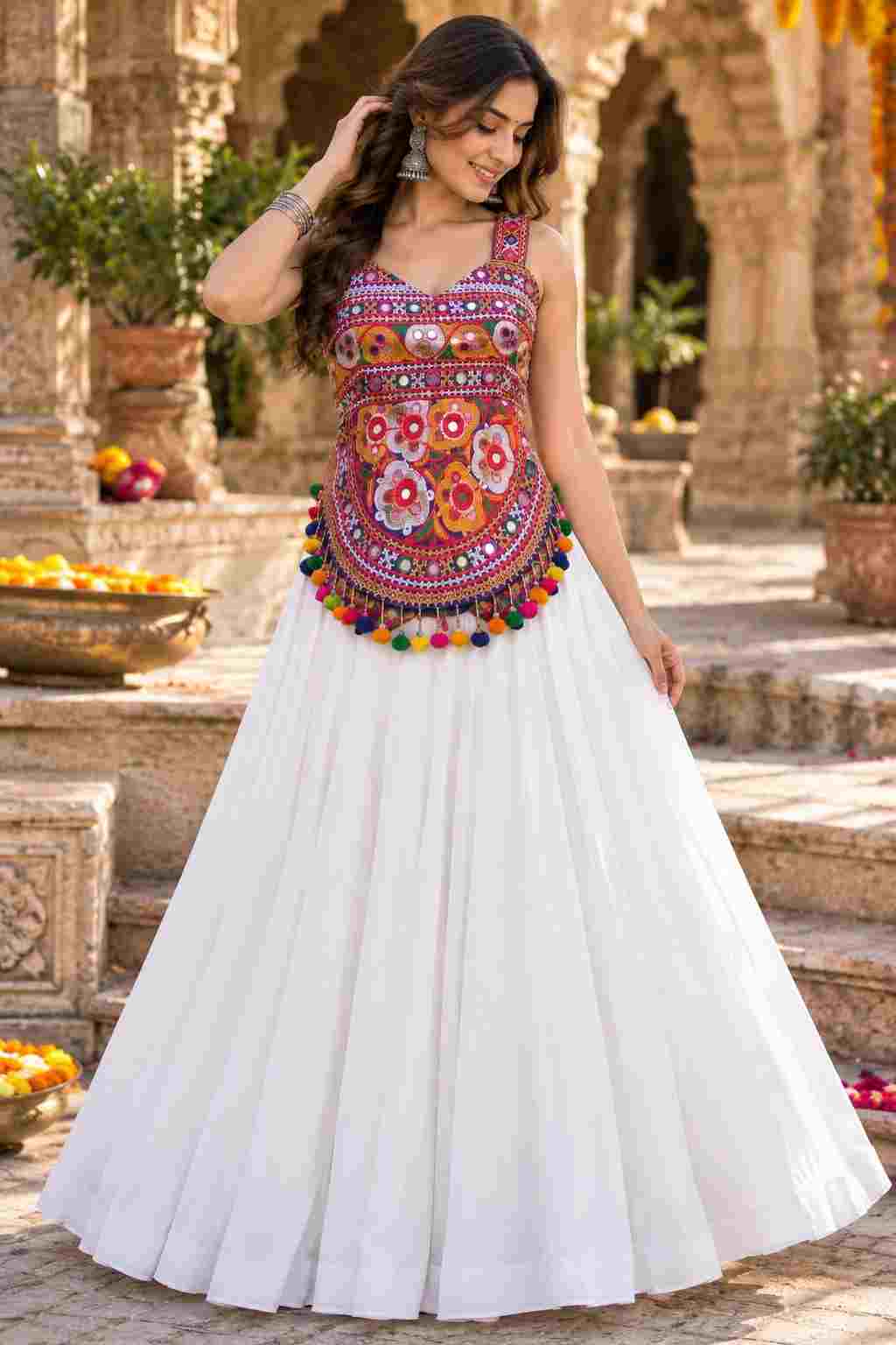 A white Navratri lehenga with a colorful embroidered mirror-work choli.   