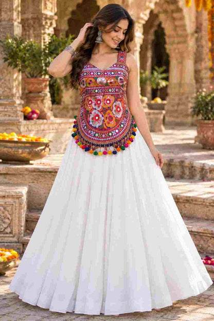 A white Navratri lehenga with a colorful embroidered mirror-work choli.   