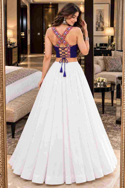 A white Navratri lehenga with a colorful embroidered mirror-work choli.