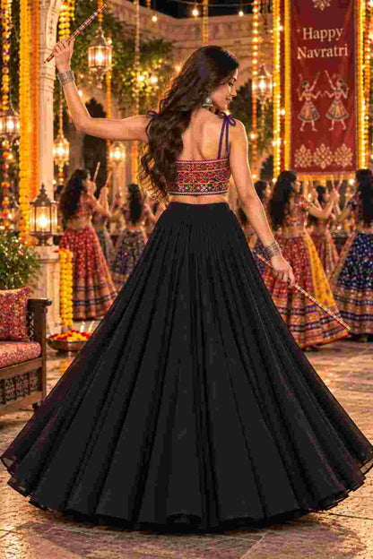 Flared black lehenga showing tie-up shoulder straps.   