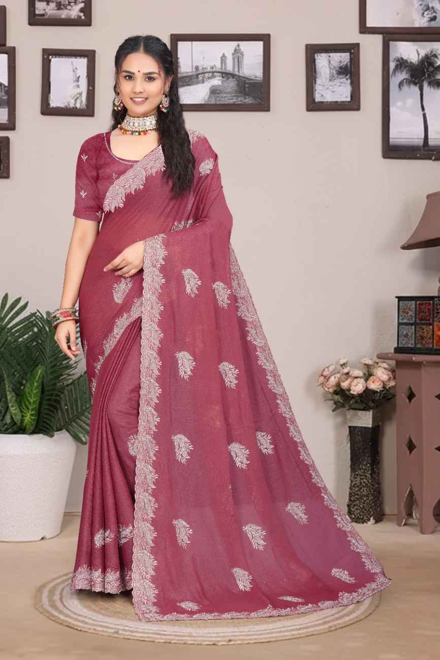 Woman wearing a maroon saree with white patterns in a room setting.