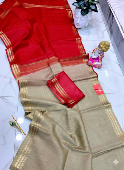 Red and beige saree with gold border on a white floor.