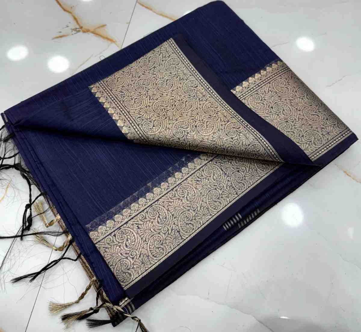 Navy blue scarf with gold intricate patterns on a white marble surface