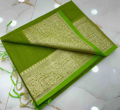 Green fabric with intricate white patterns on a white tiled floor
