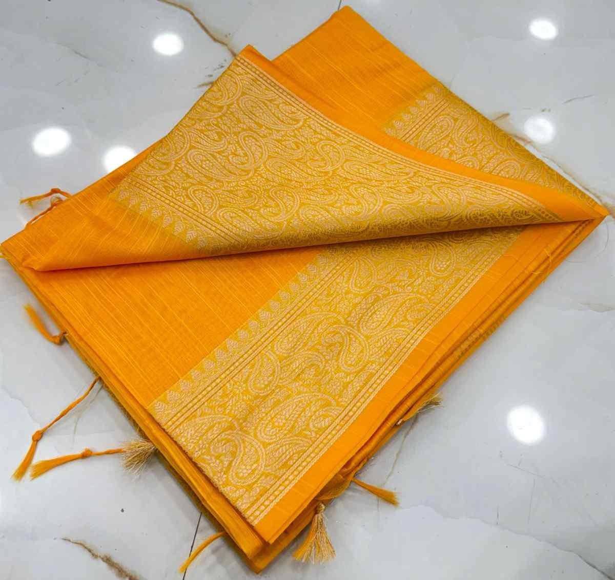Orange fabric with intricate patterns on a white surface