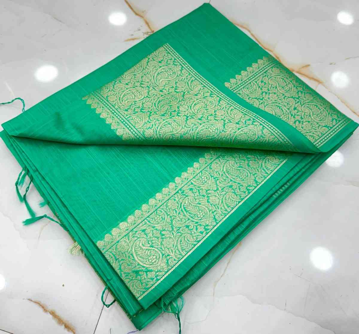 Green saree with gold patterns on a white background