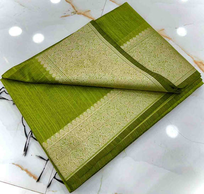 Green saree with gold patterns on a white marble surface