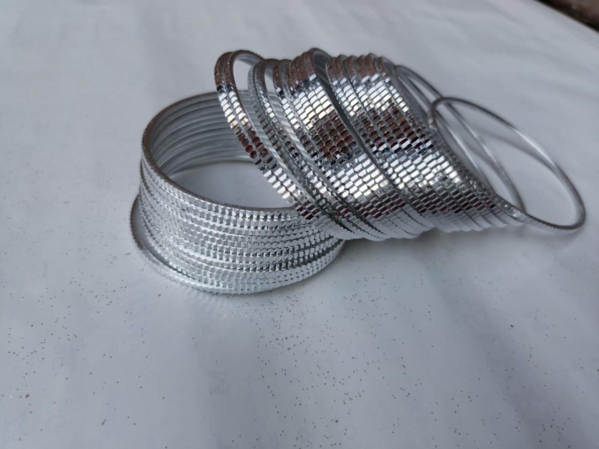 Silver bangles on a light gray surface