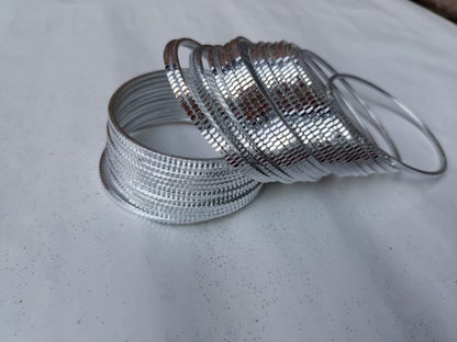 Silver bangles on a light gray surface