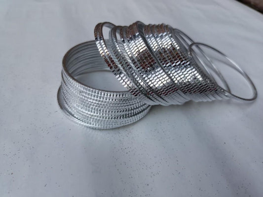 Silver bangles on a light gray surface