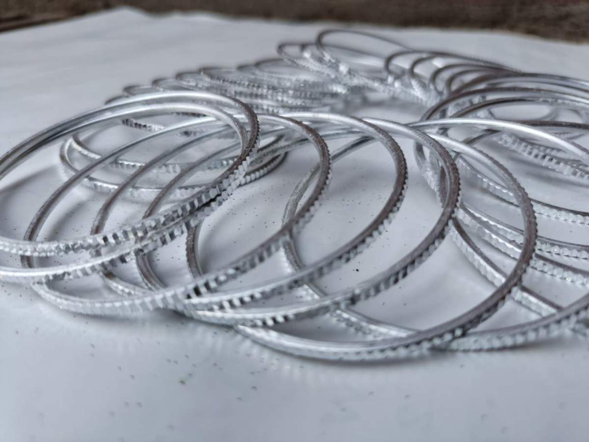 Silver bangles stacked on a light surface