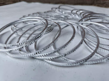 Silver bangles stacked on a light surface
