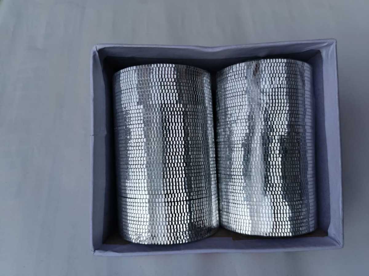 Two rolls of silver mesh in a gray box on a gray background
