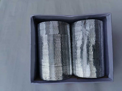 Two rolls of silver mesh in a gray box on a gray background