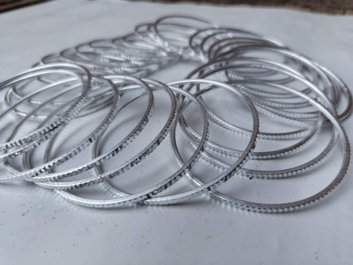 Stack of metal piston rings on a white surface