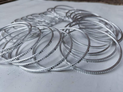 Stack of metal piston rings on a white surface