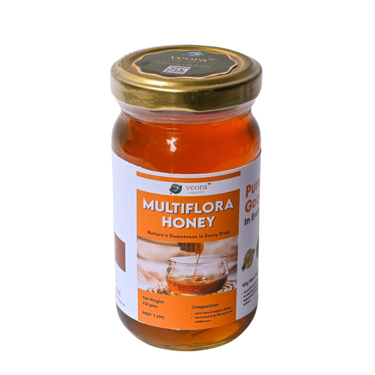 Jar of multiflora honey with a gold lid on a white background