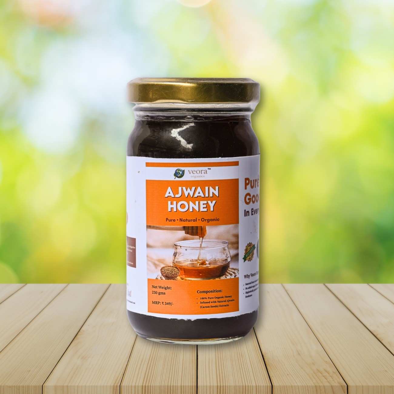 Jar of Ajwain honey on a wooden surface with a blurred green background