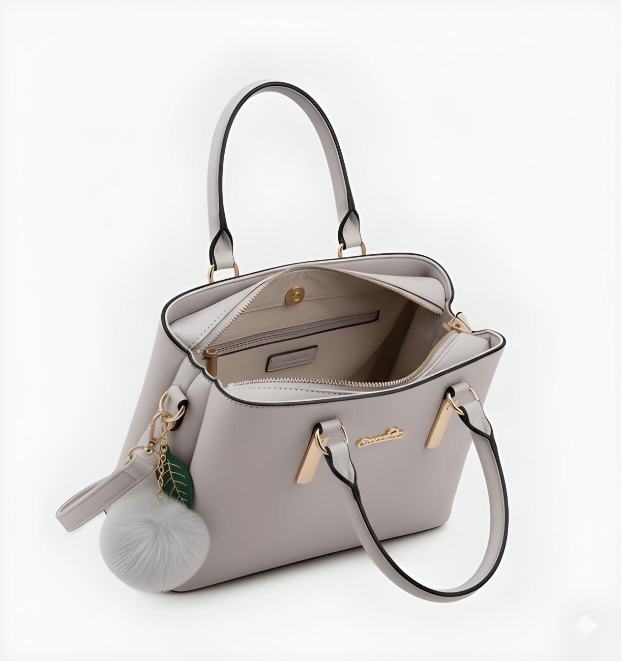 Light gray handbag with a decorative charm on a white background