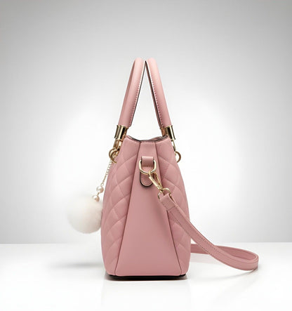 Pink quilted handbag with gold accents on a light gray background