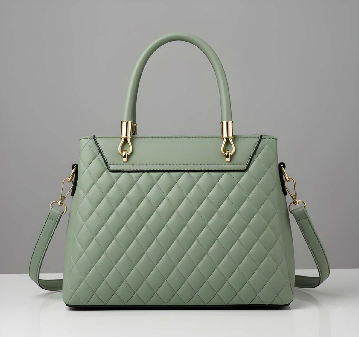 Green quilted handbag with gold accents on a gray background