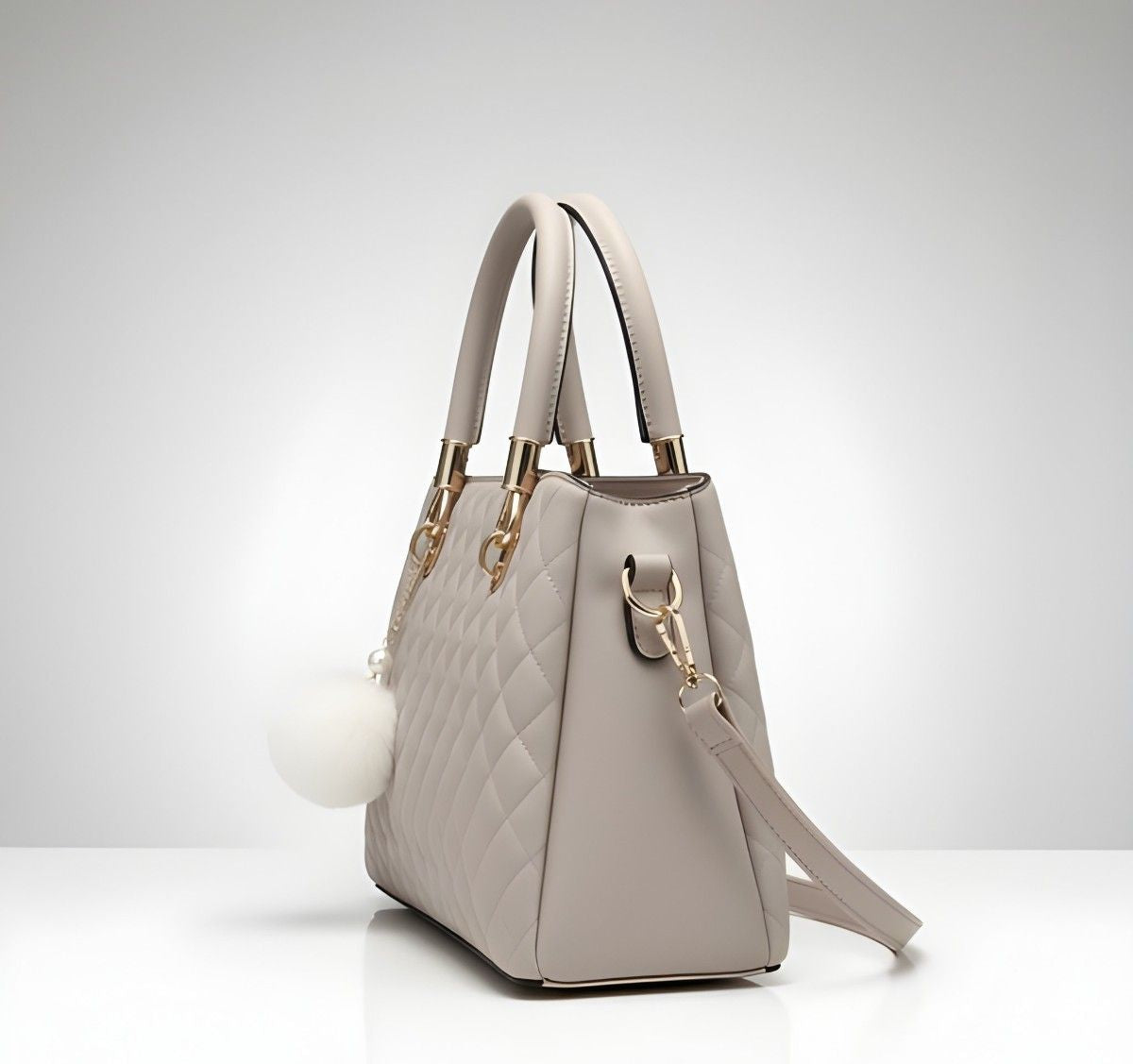 Light gray handbag with gold accents on a white background