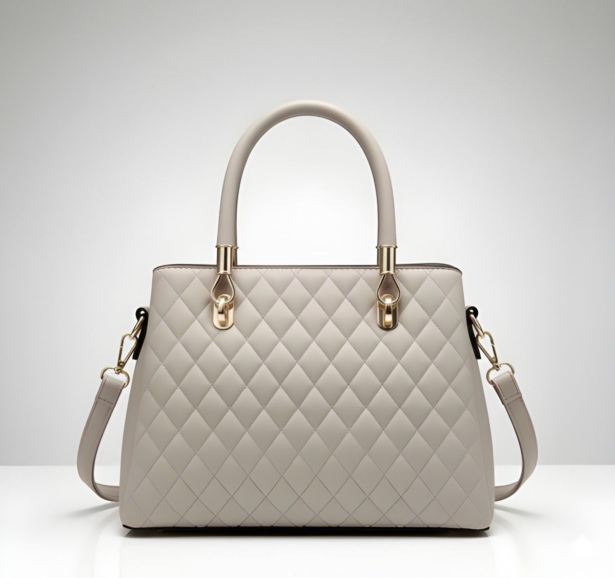 Quilted handbag with gold accents on a light gray background