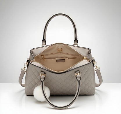 Gray quilted handbag with a fluffy white handle on a light gray background