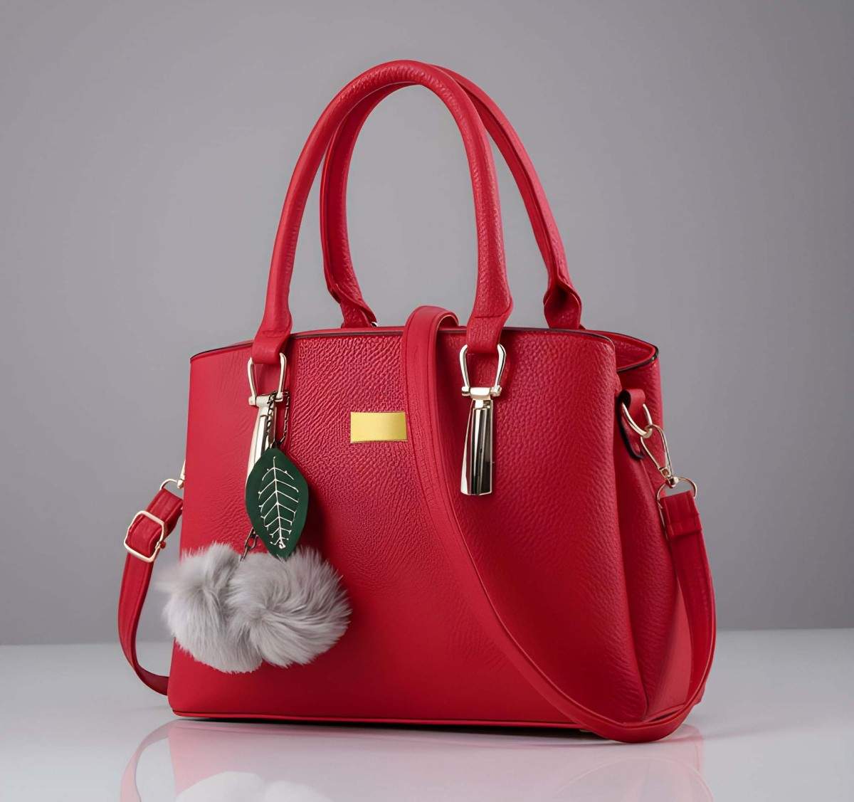 Red handbag with decorative charm on a gray background