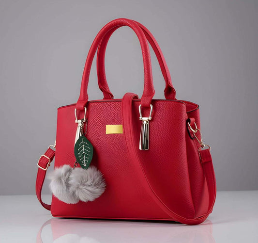 Red handbag with decorative charm on a gray background