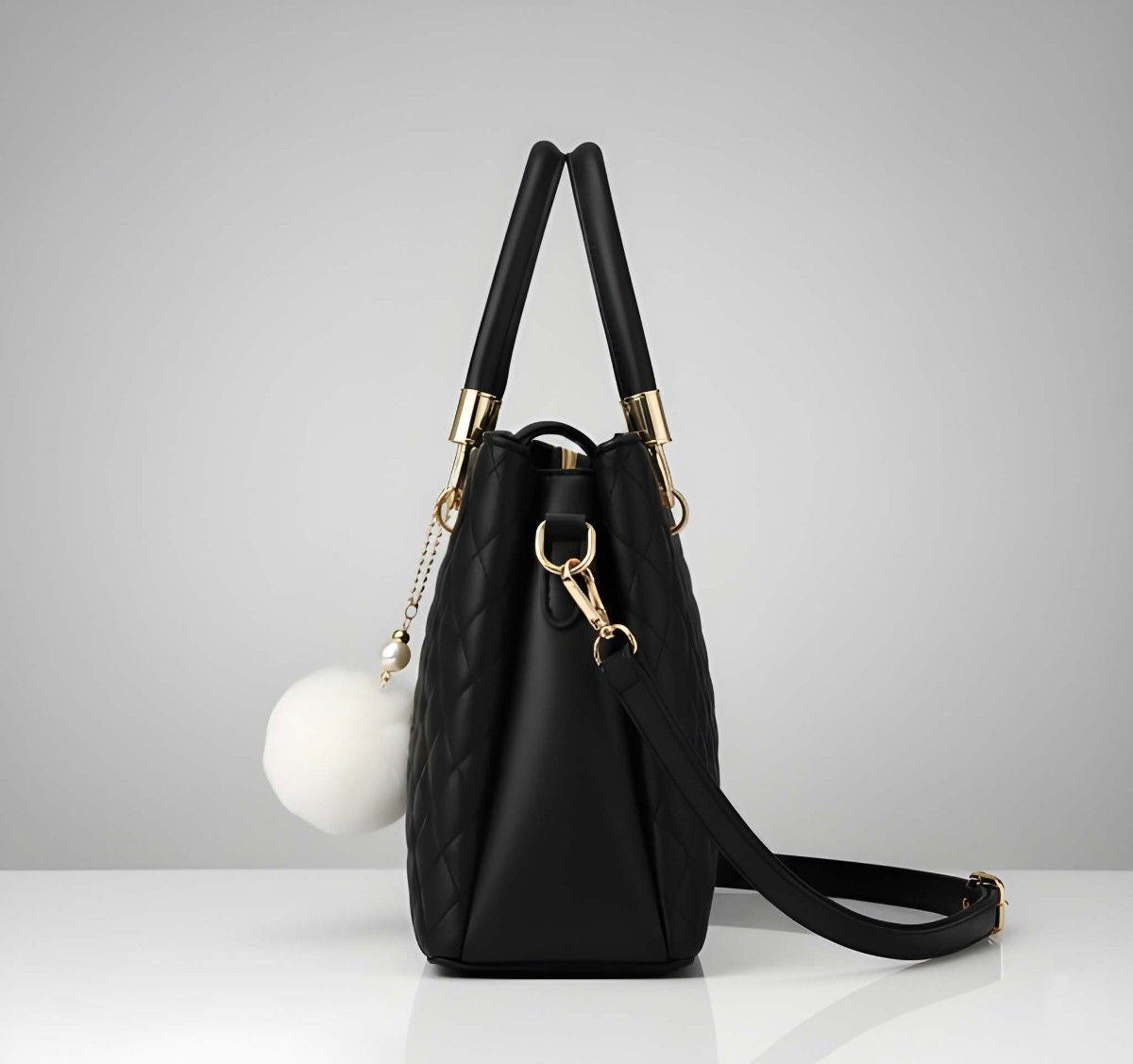 Black handbag with gold accents on a light gray background