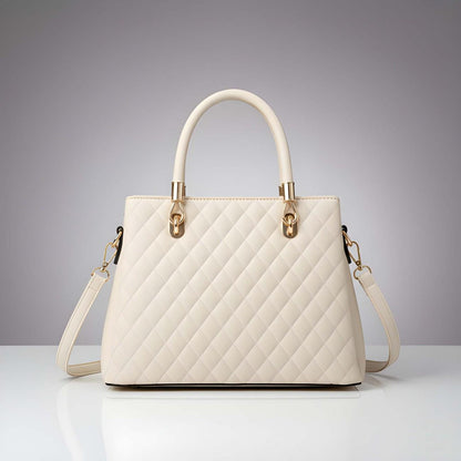 White quilted handbag with gold accents on a gray background