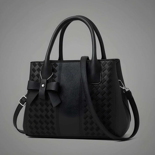 Black handbag with a textured pattern on a gray background