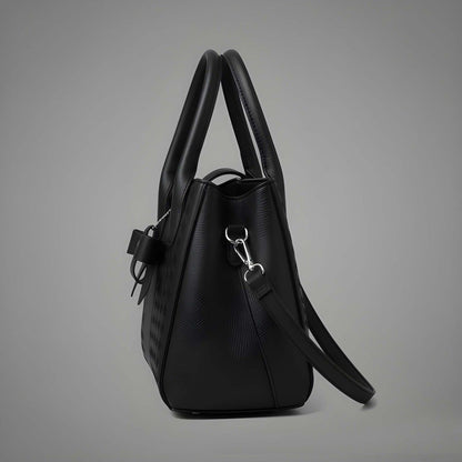 Black handbag with a strap on a gray background