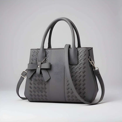 Gray handbag with a bow detail on a light gray background