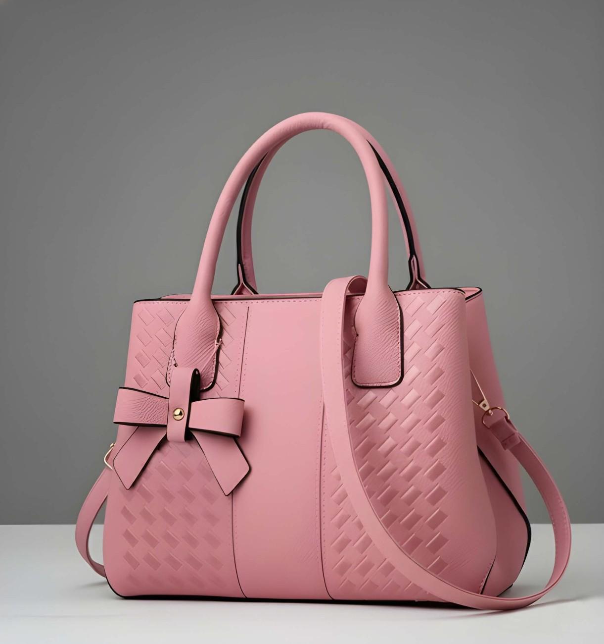 Pink handbag with a bow detail on a gray background
