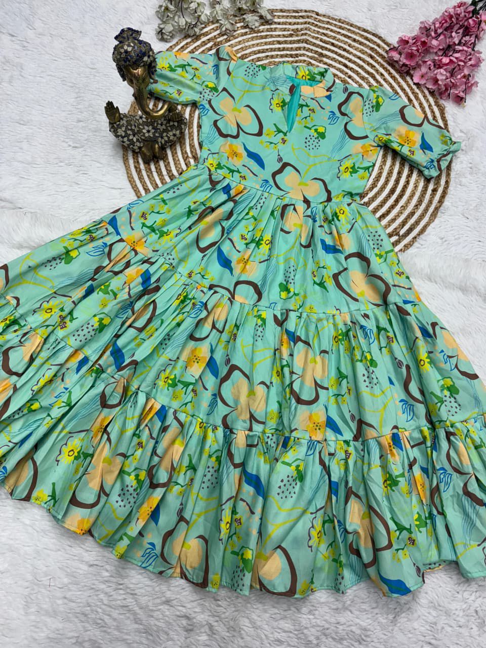 Green floral dress on a white surface with decorative elements.