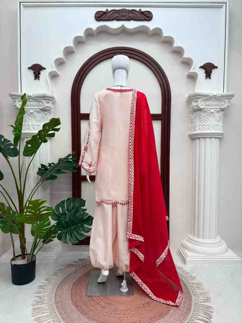Woman wearing beige embroidered harem salwar suit with red dupatta