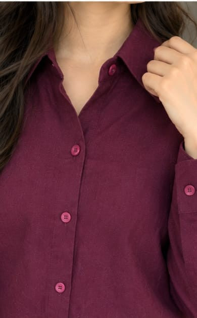 Close-up of spread collar and button closure on burgundy synthetic shirt.